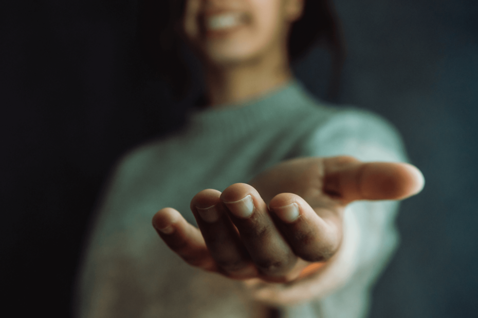 A person reaching their hand out to help others.