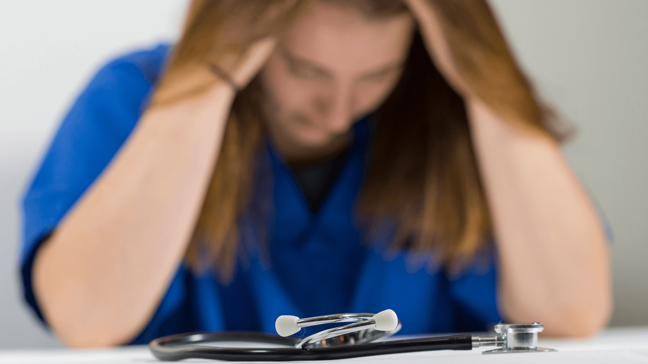 A stethoscope and a close-up of a nurse with her head in her hands.