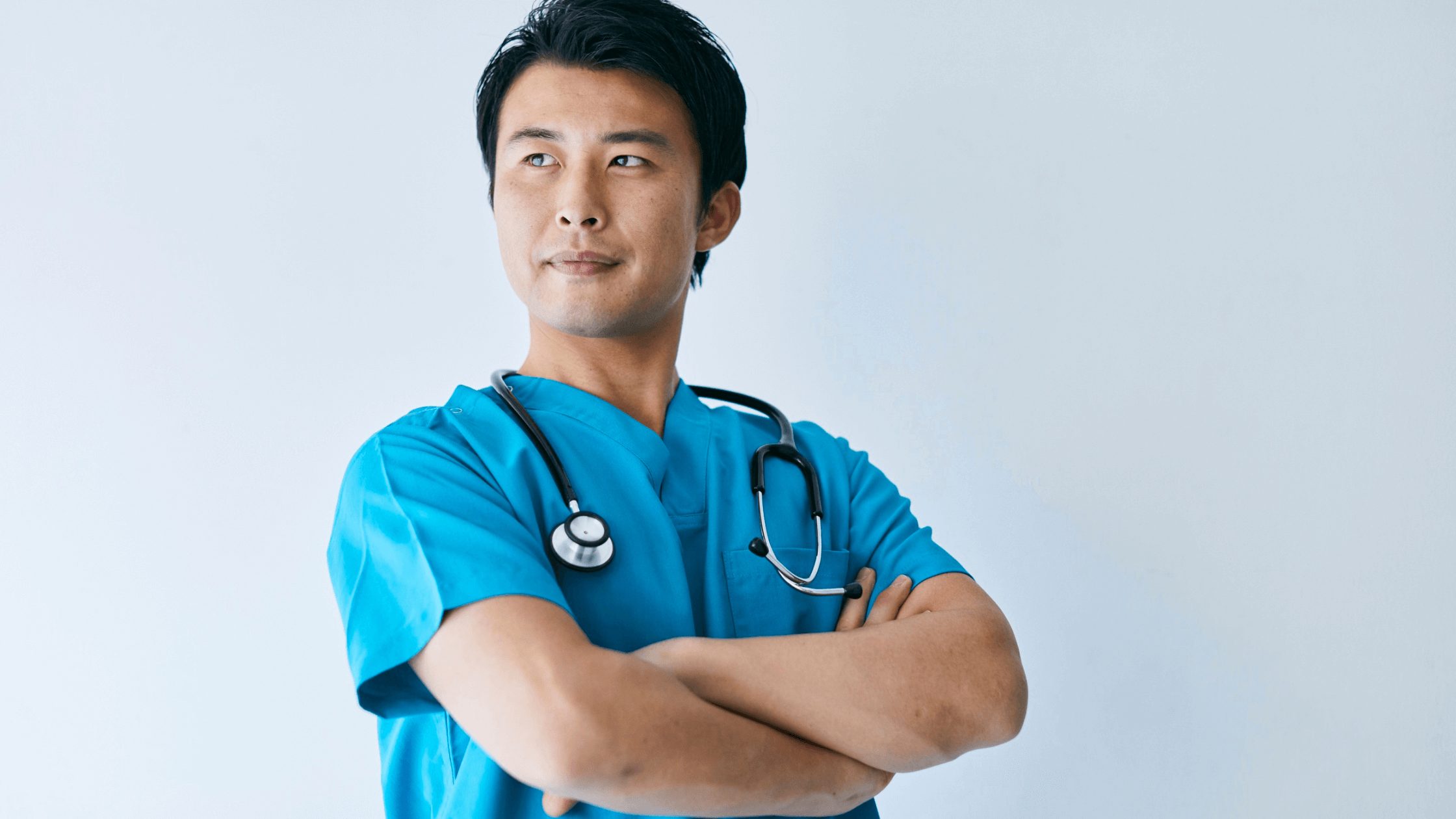 A nurse standing with his arms crossed