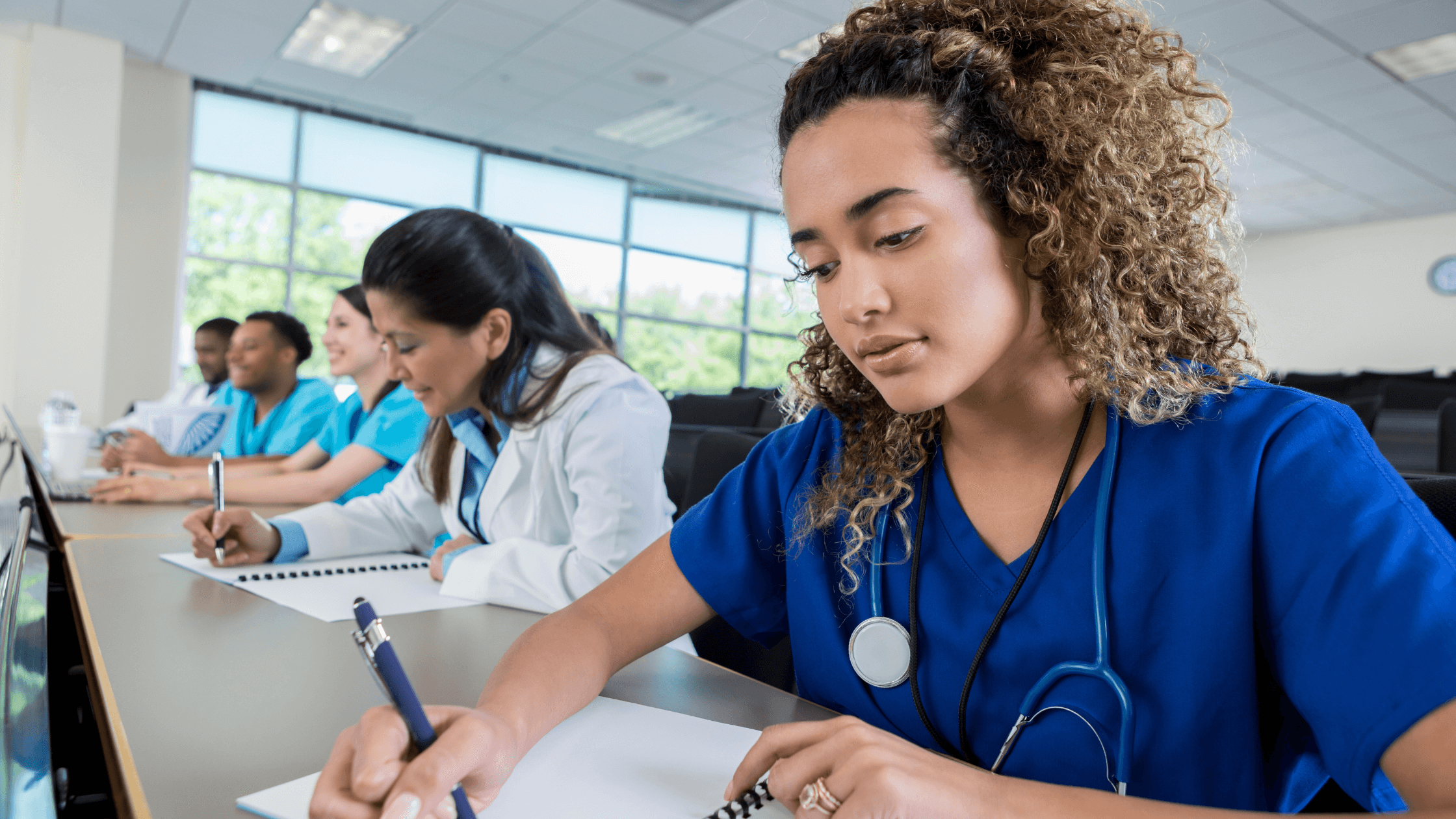 A nurse taking notes in a classroom