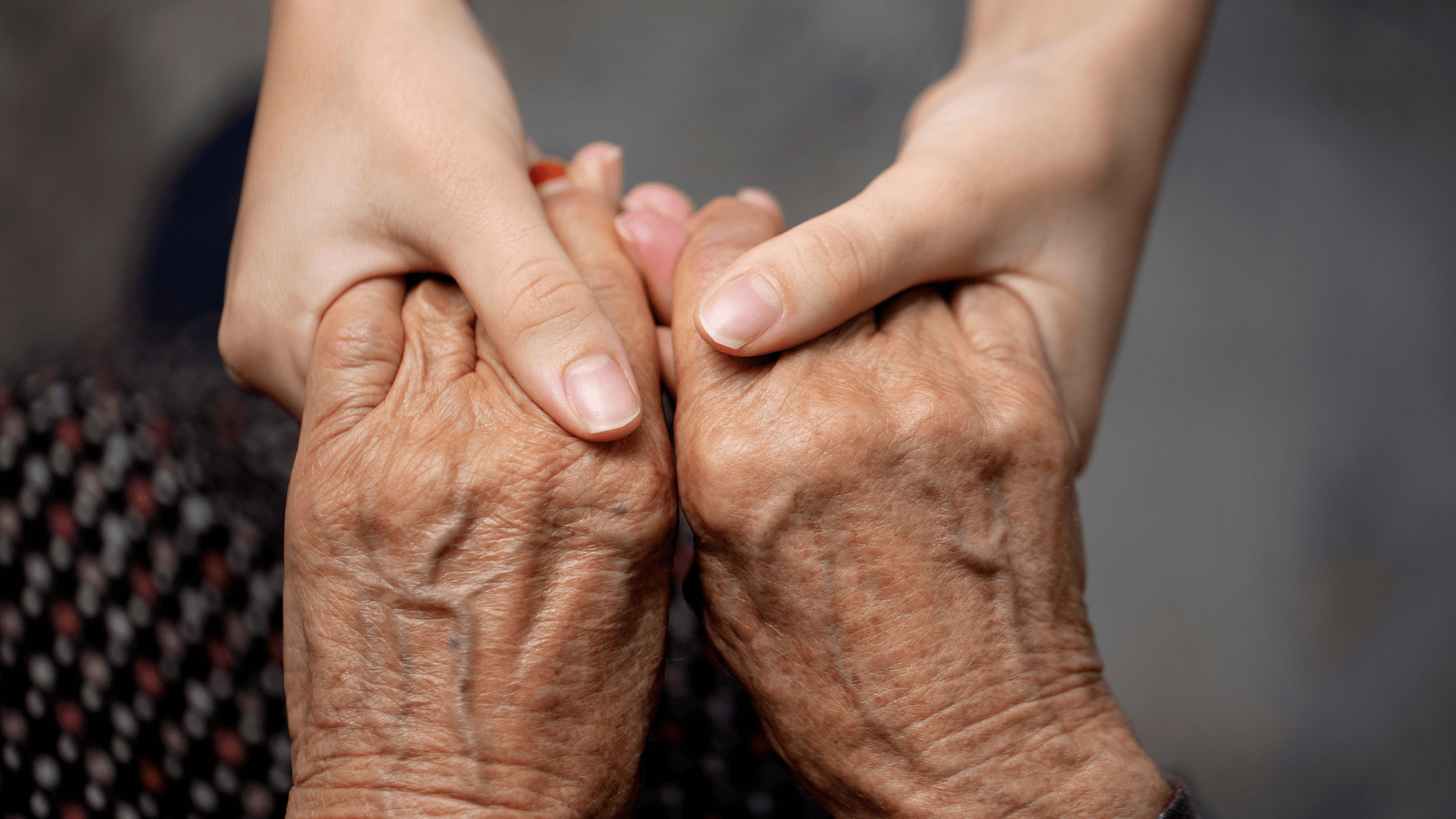 A young set of hands holding onto an older set of hands.