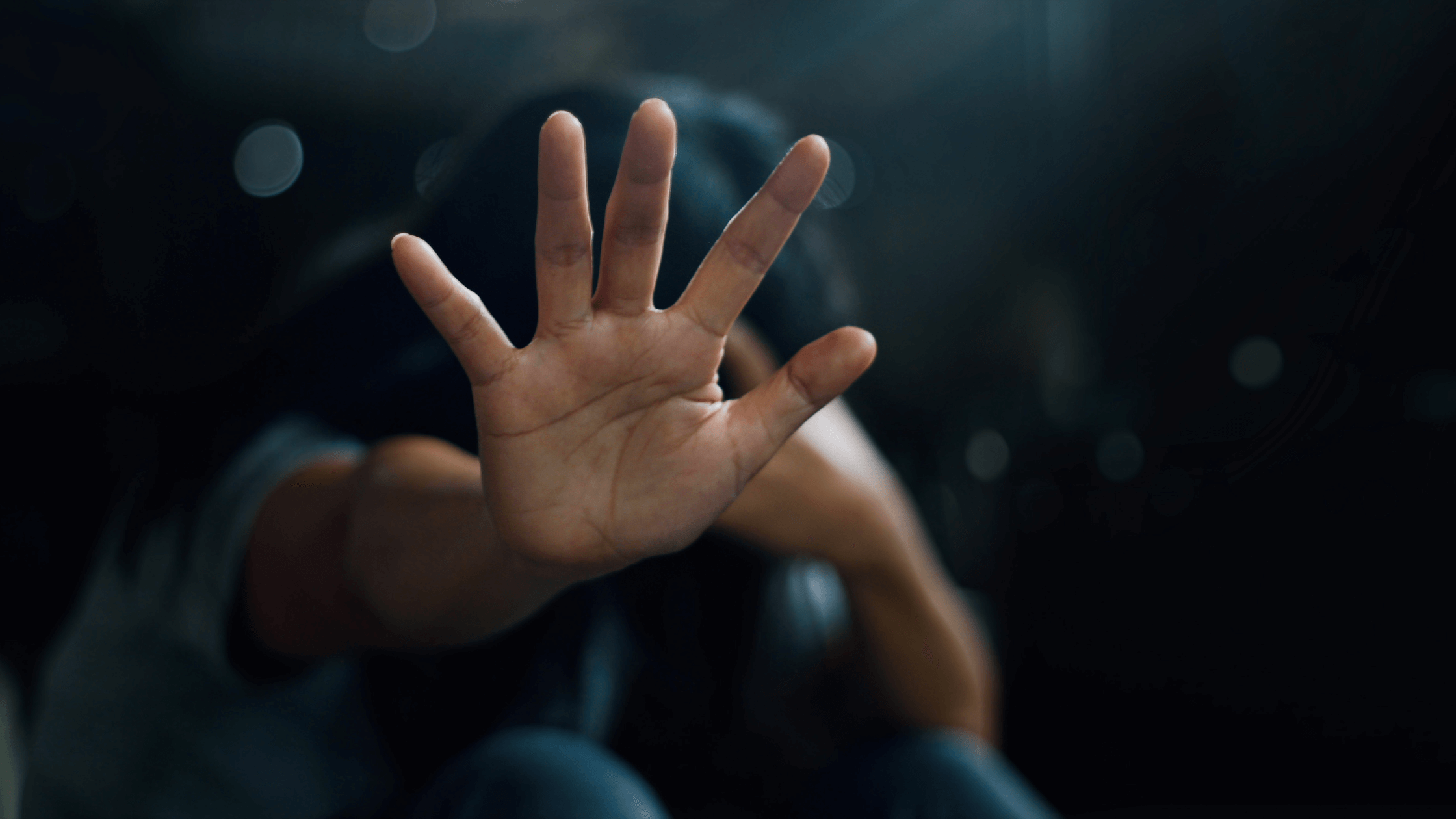 A close up of the palm of a person's hand as they reach out like they's saying stop.