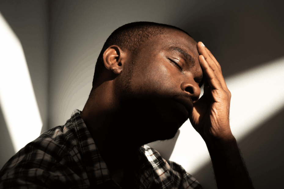 A man with his hand on his head like his head hurts.