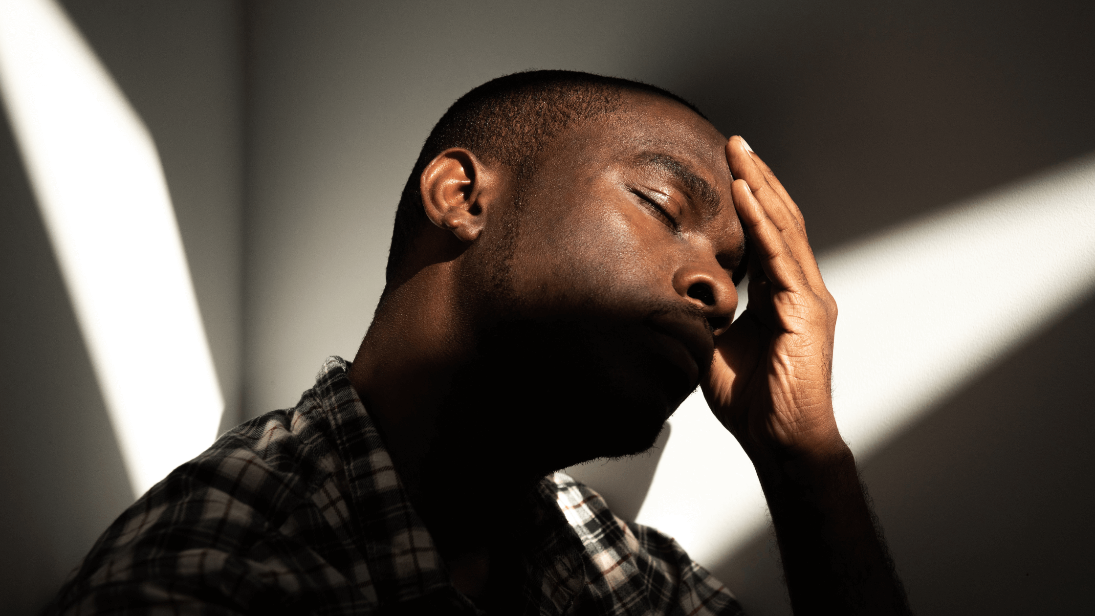 A man with his hand on his head like his head hurts.